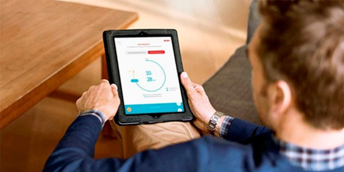 Un cliente consulta su consumo energético a través de una aplicación en una tablet.