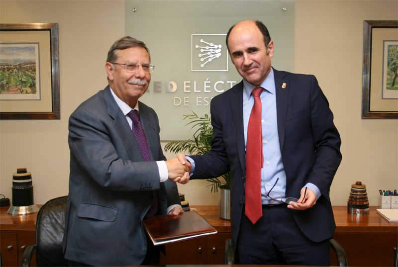 José Folgado y Manu Ayerdi se estrechan las manos en un despacho de la sede de Red Eléctrica de España. 