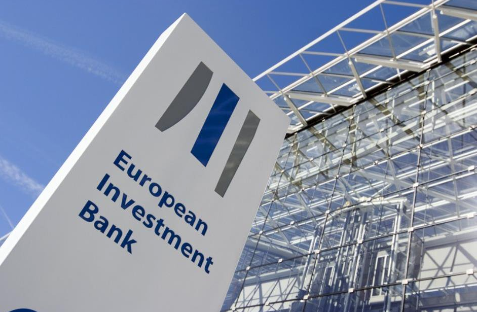 Tótem con el logo del BEI ante la fachada de esta entidad en Bruselas. 