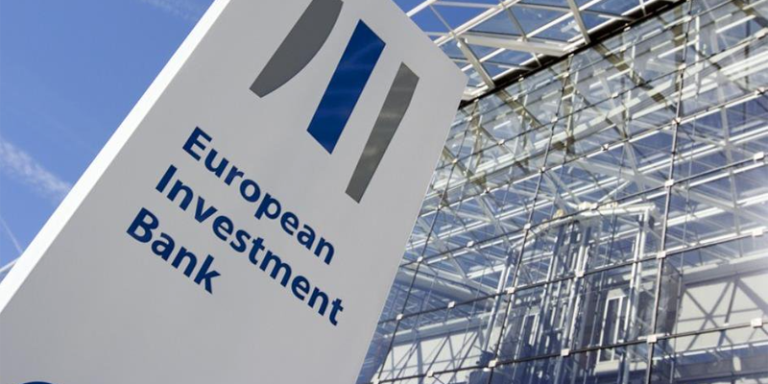Tótem con el logo del BEI ante la fachada de esta entidad en Bruselas.