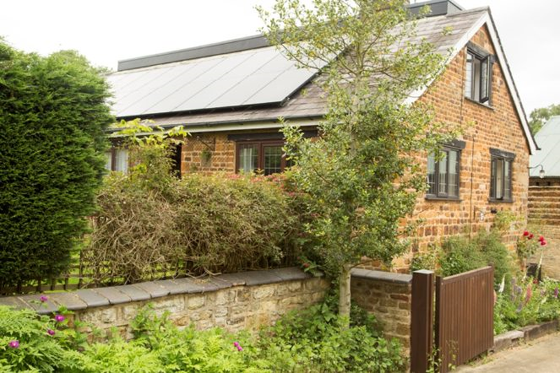 Vivienda unifamiliar con tejado a dos aguas y paneles fotovoltaicos sobre la cubierta. 