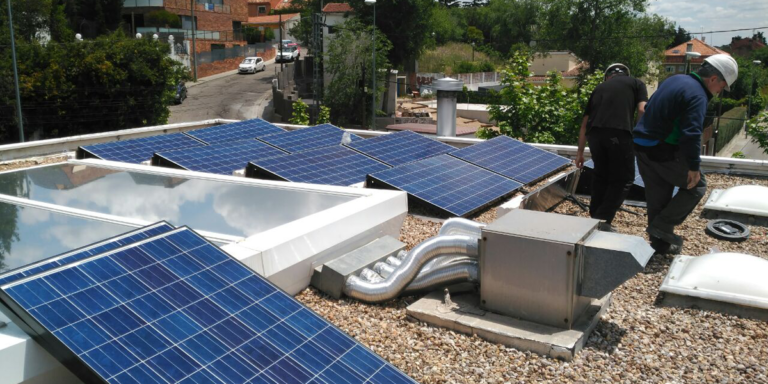 Profesionales instalando paneles solares sobre la cubierta de una vivienda.