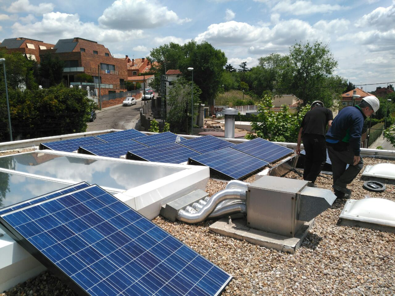 Profesionales instalando paneles solares sobre la cubierta de una vivienda. 