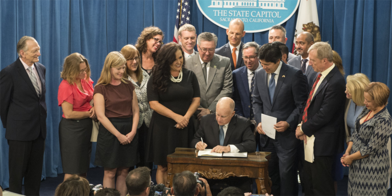 El gobernador de California durante la ratificación del proyecto ley SB100 aprobado por el Senado Californiano.