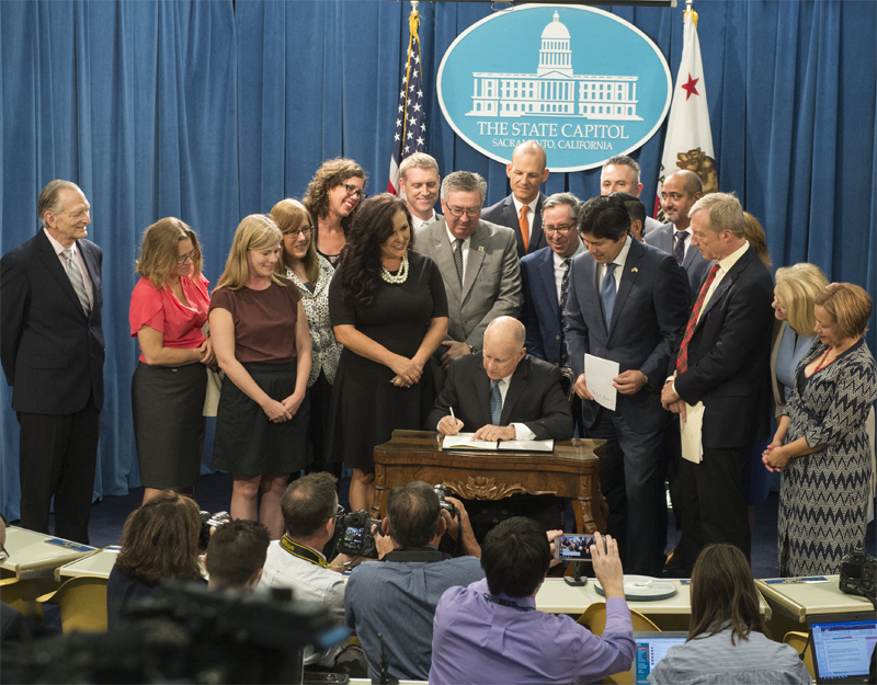 El gobernador de California durante la ratificación del proyecto ley SB100 aprobado por el Senado Californiano. 