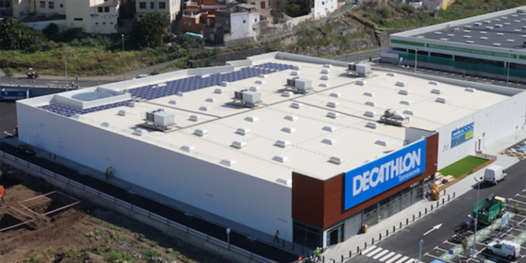 Vista aérea de una tienda Decathlon con paneles solares fotovoltaicos sobre la cubierta.