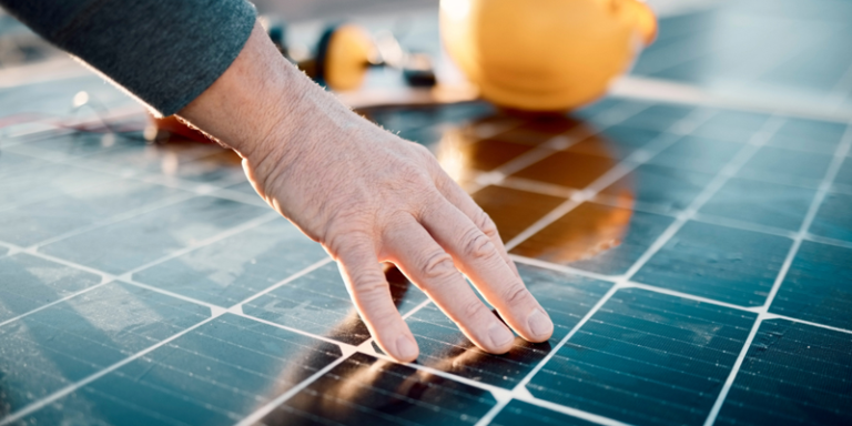 mano sobre la placa fotovoltaica